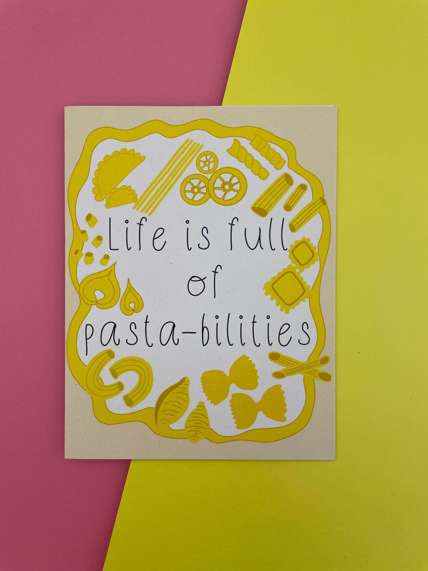 Card with pasta illustrations and text 'Life is full of pasta-bilities' on a yellow and pink background.