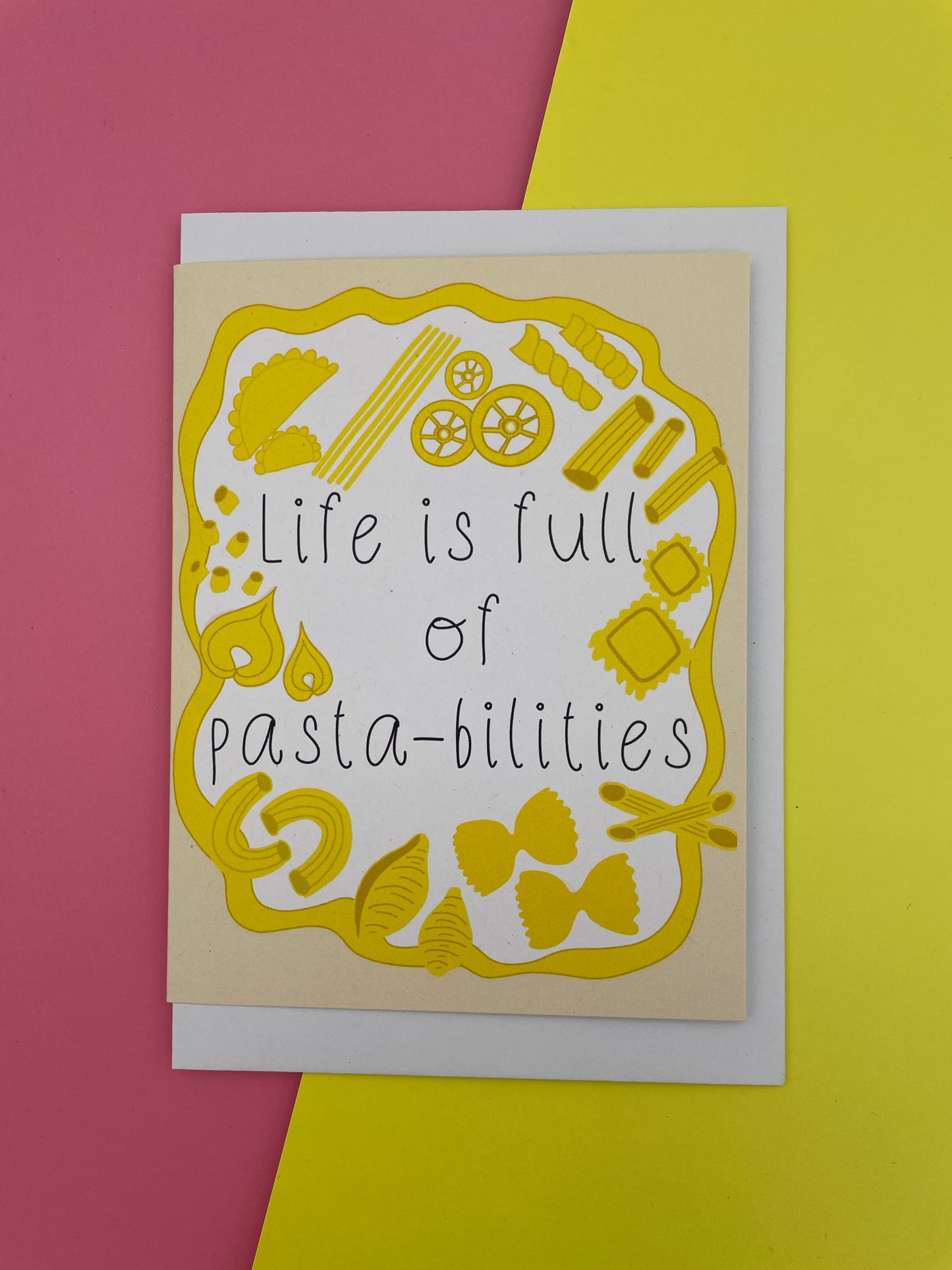 Card with pasta illustrations and text 'Life is full of pastabilities' on a yellow and pink background.