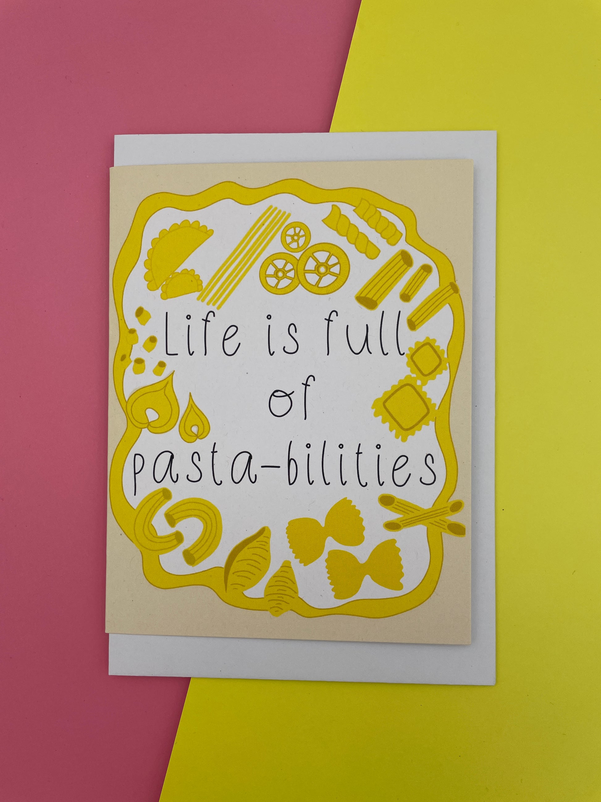 Card with pasta illustrations and text 'Life is full of pastabilities' on a yellow and pink background.