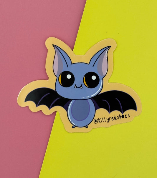 A cute purple and black cartoon bat sticker on an orange background. The bat has big eyes and small fangs.