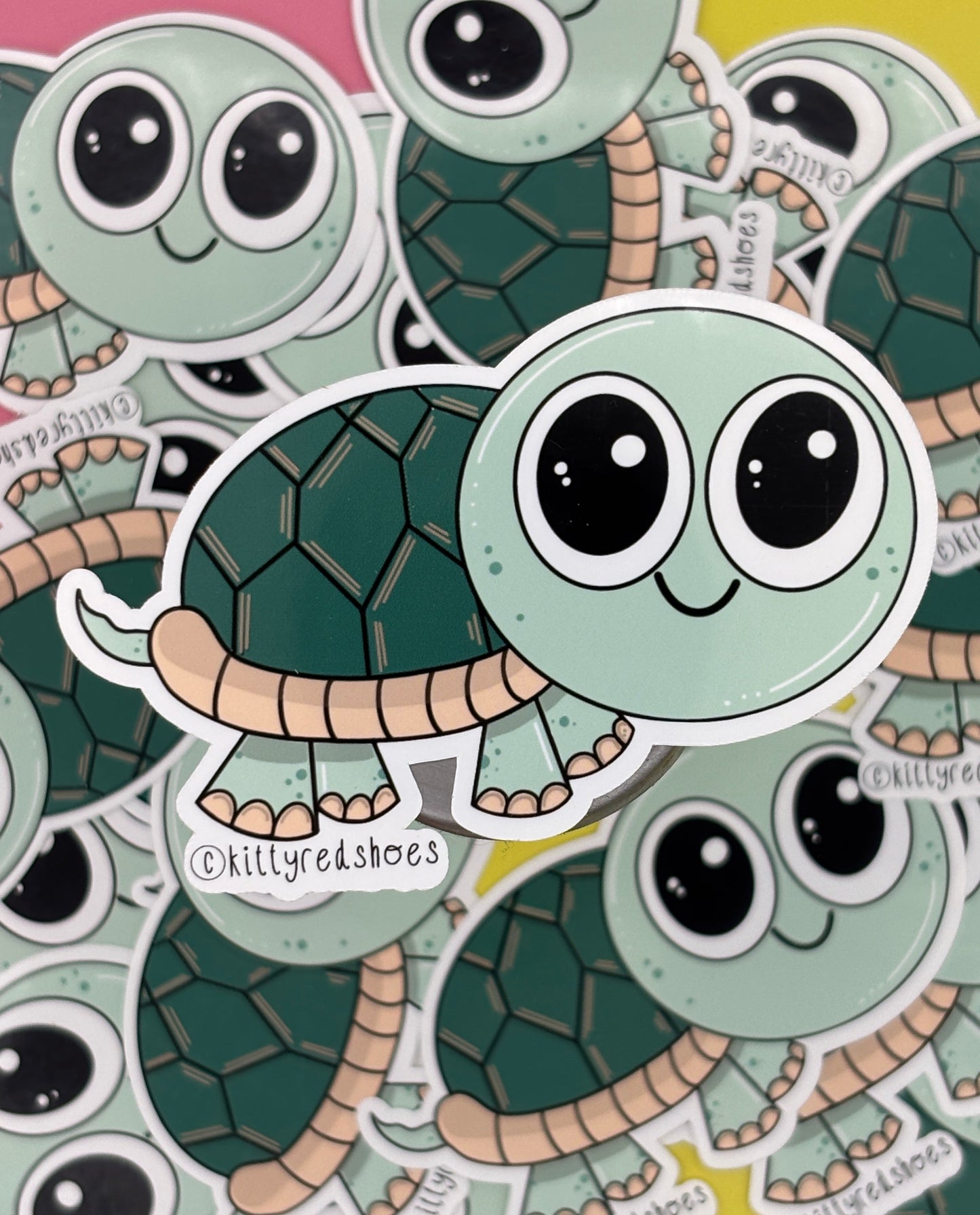 A cute green smiling turtle sticker with text copyright kittyredshoes resting on lots of the same sticker.